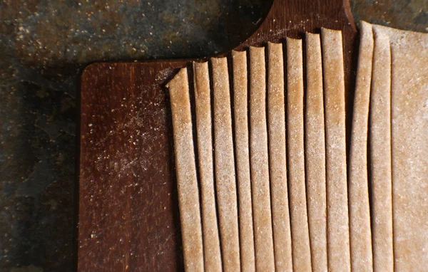 Bir ahşap tahta üzerinde tam buğday unu makarna — Stok fotoğraf