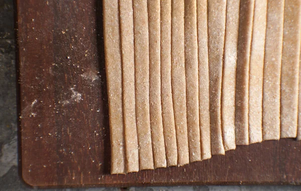 Bir ahşap tahta en iyi görünümde tam buğday unu makarna — Stok fotoğraf