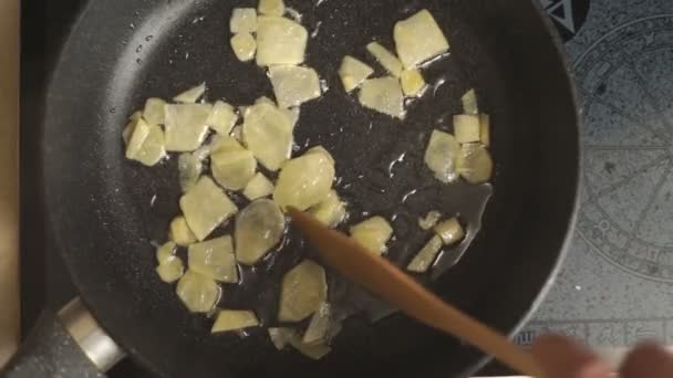 Roosteren stukjes gember in een pan in bovenaanzicht van het olie van de video — Stockvideo