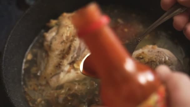 Molho de pimenta quente é derramado em peitos de frango em uma panela — Vídeo de Stock