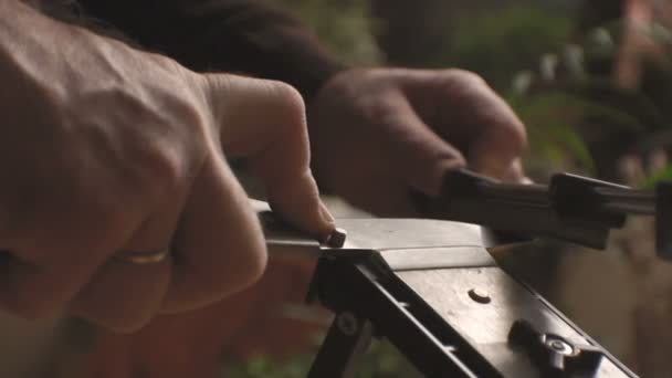 Sacapuntas para cuchillos, cuchillo de cocina sobre el fondo de un video de flores — Vídeo de stock