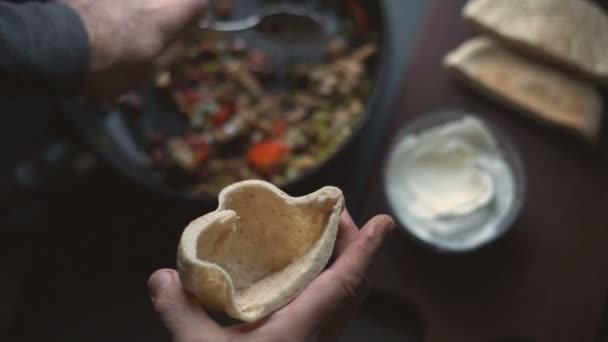 O homem está a encher uma tortilha com recheio. Prato mexicano. Vídeo — Vídeo de Stock