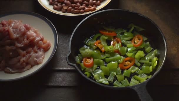 Кусочки курицы, бобы. Перец и чили в сковородке крупным планом. Видео — стоковое видео