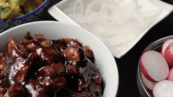 Bitar av kycklingfilé i teriyaki sås, broccoli och rädisor. Asiatiska köket. Video — Stockvideo