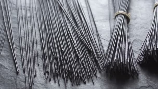 Black rice noodles on a gray stone top view. Asian cuisine. Video desaturate — Stock Video