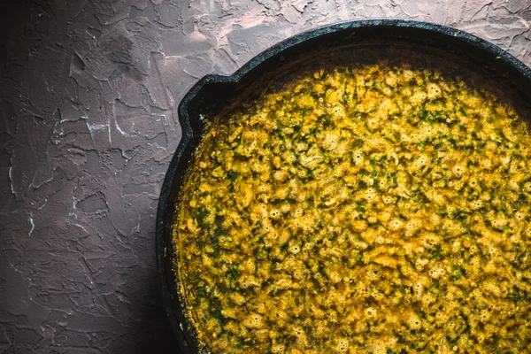 Gelbe Currypaste in einer gusseisernen Pfanne in Nahaufnahme. Indisches Essen — Stockfoto