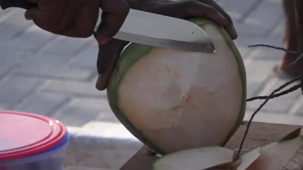 Az ember egy fiatal friss kókusz darab levágja. Maldív-szigetek videóinak közelről — Stock videók