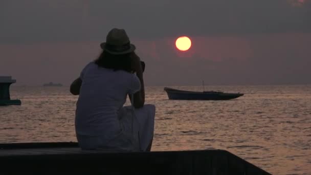 Dívka se dívá na západ slunce nad Indickým oceánem. Detailní video Maledivy — Stock video