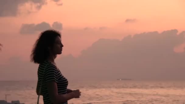 Girl is looking at a pink cloudy sky. Maldives video — Stock Video