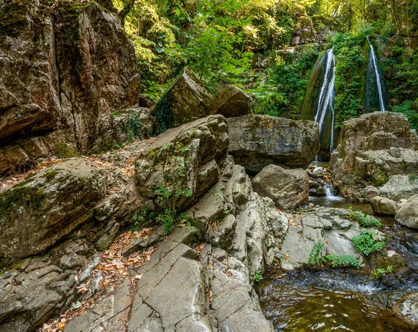 Wasserfall und Felsen auf dem Hintergrund von Bäumen in Griechenland — Stockfoto