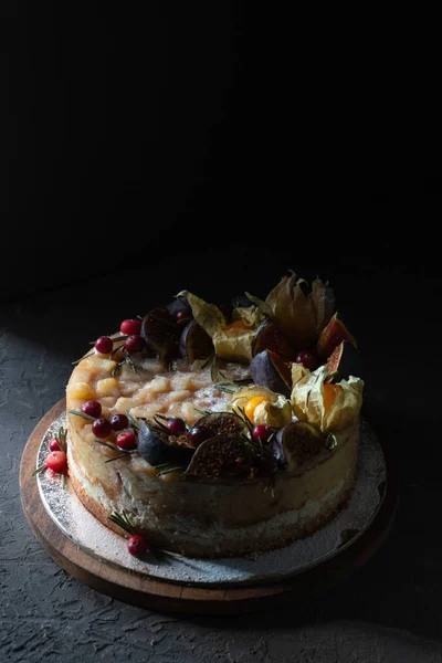 Cheesecake met vijgen en fysalis op een houten plank — Stockfoto
