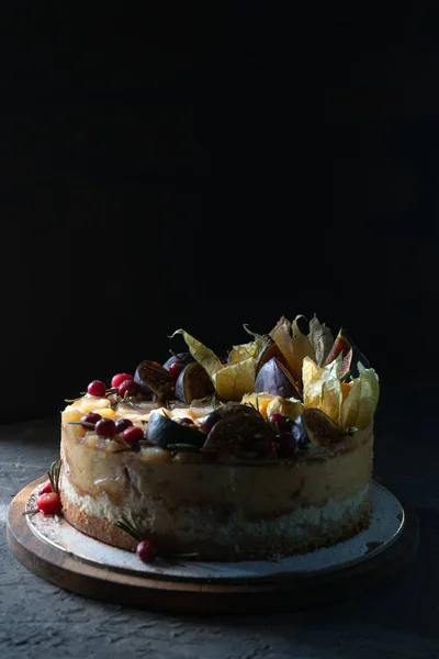 Cheesecake with figs and physalis on a wooden board — Stock Photo, Image