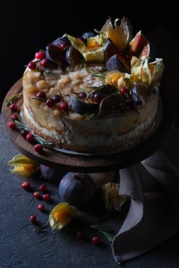 Tutacağında meyve olan peynirli kek ve peçete.