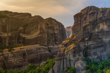 Gökyüzüne karşı yüksek dağlar ve yeşil ağaçlar