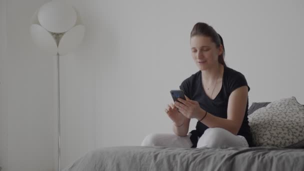 Jeune femme tient un téléphone portable dans ses mains plan général — Video