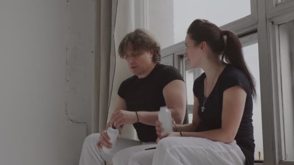Тренер и студент расслабиться и пить воду после тренировки вид сбоку — стоковое видео