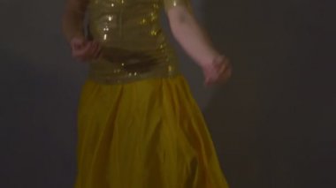 Sarı elbiseli kız geleneksel Hint dansı yapıyor.