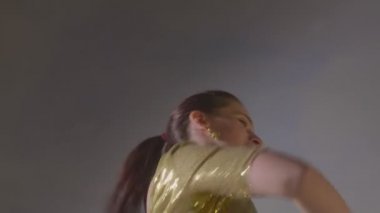 Sarı sarili sanatçı Hint dansını yakından yapıyor.