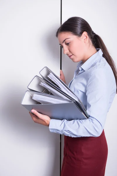 Young female professional is putting binders into the cabinet — Stock Photo, Image