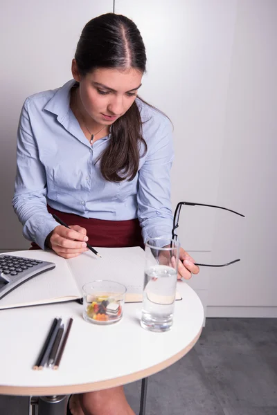 Giovane professionista femminile sta lavorando con i suoi occhiali nel suo han — Foto Stock