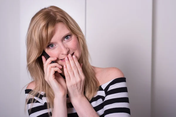 Vacker blond kvinna är mycket upprörd under ett telefonsamtal — Stockfoto