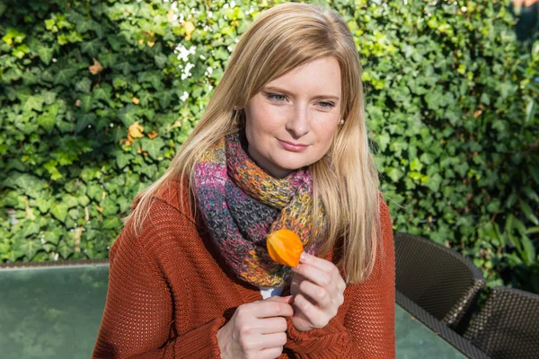 Atrakcyjna kobieta z kwiatu w ręku ciesząc się słońcem w jesieni — Zdjęcie stockowe