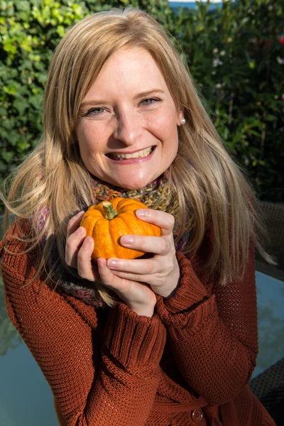 Attraktiv blond kvinna är glad med pumpa i höst — Stockfoto