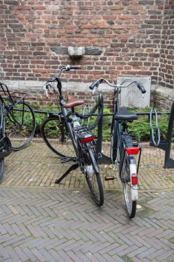 Venlo şehir merkezinde bir tuğla duvara iki bisiklet
