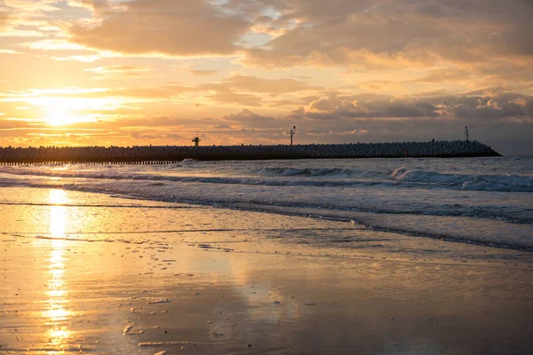 Pôr do sol no cais na praia do Mar do Norte de Cadzand, Holanda — Fotografia de Stock