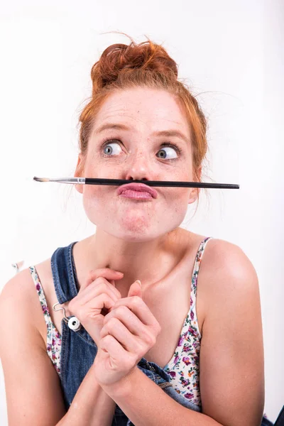 Har ung rödhårig kvinna gör kul med en pensel — Stockfoto