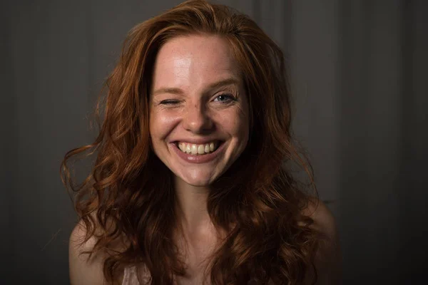 Young red-haired woman winking at the camera — Stock Photo, Image