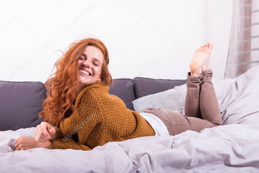 Рыжая дама на кровати переживает вагинальный секс