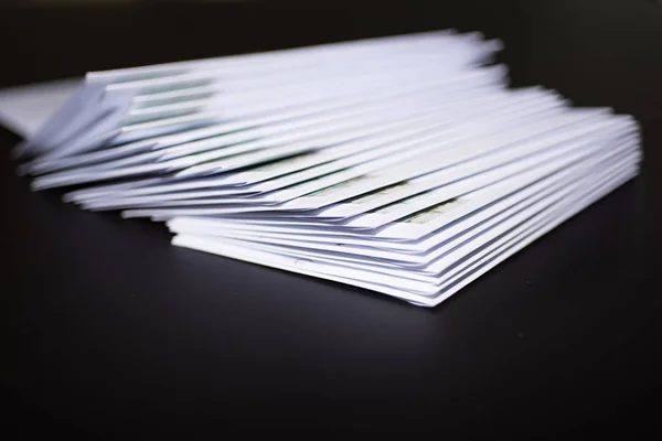 Stos listów ofrankowane w koperty białe na czarnym tle — Zdjęcie stockowe