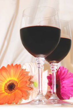 kırmızı şarap gözlük ve çiçekler. seçici odak. 