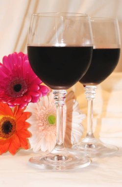 kırmızı şarap gözlük ve çiçekler. seçici odak. 