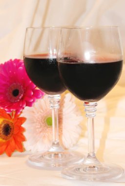 kırmızı şarap gözlük ve çiçekler. seçici odak. 