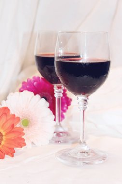 kırmızı şarap gözlük ve çiçekler. seçici odak. 