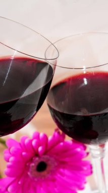 kırmızı şarap gözlük ve çiçekler. seçici odak. 