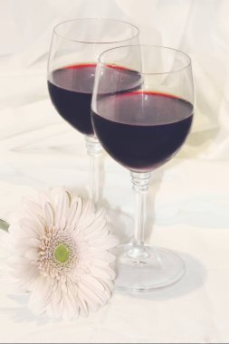 kırmızı şarap gözlük ve çiçekler. seçici odak. 