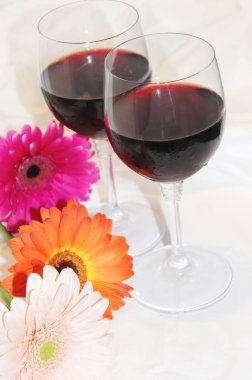 kırmızı şarap gözlük ve çiçekler. seçici odak. 