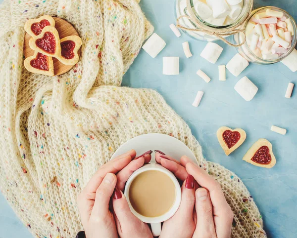 Kakao ve çerezleri kalp aşıkların elinde. Seçici odak. 