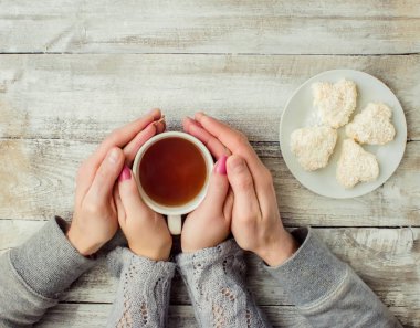 çay aşıkların eller. Ahşap arka plan üzerinde.