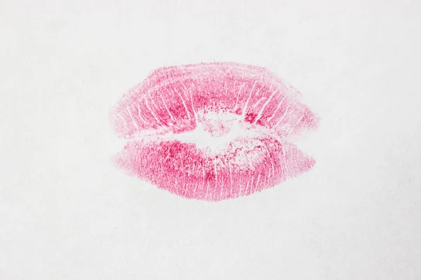 Un beso sobre un lápiz labial de fondo blanco. enfoque selectivo . — Foto de Stock