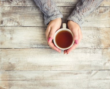 çay aşıkların eller. Ahşap arka plan üzerinde.