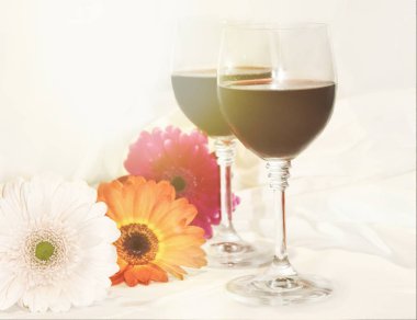 kırmızı şarap gözlük ve çiçekler. seçici odak. 