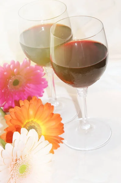 Vin rouge dans des verres et des fleurs. focus sélectif . — Photo