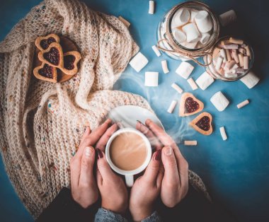 Kakao ve çerezleri kalp aşıkların elinde. Seçici odak. 