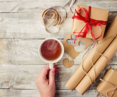 çay aşıkların eller. Ahşap arka plan üzerinde.