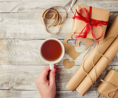 çay aşıkların eller. Ahşap arka plan üzerinde.