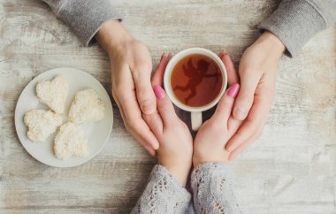 çay aşıkların eller. Ahşap arka plan üzerinde.